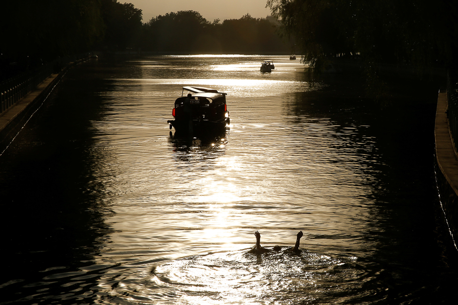 A man swims in Houhai lake on a hot summer day in Beijing, China. PHOTO: REUTERS