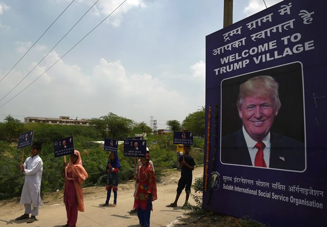 Indian children hold placards by the entrance gate of Marora village, which has been unofficially renamed 'Trump Village," about 100km from New Delhi, on June 23, 2017. 
PHOTO: AFP