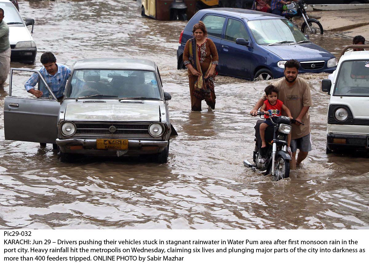 Wreaking havoc: Drivers pull their vehicles stranded in low H2O nearby Karachi’s Water Pump area. PHOTO: ONLINE