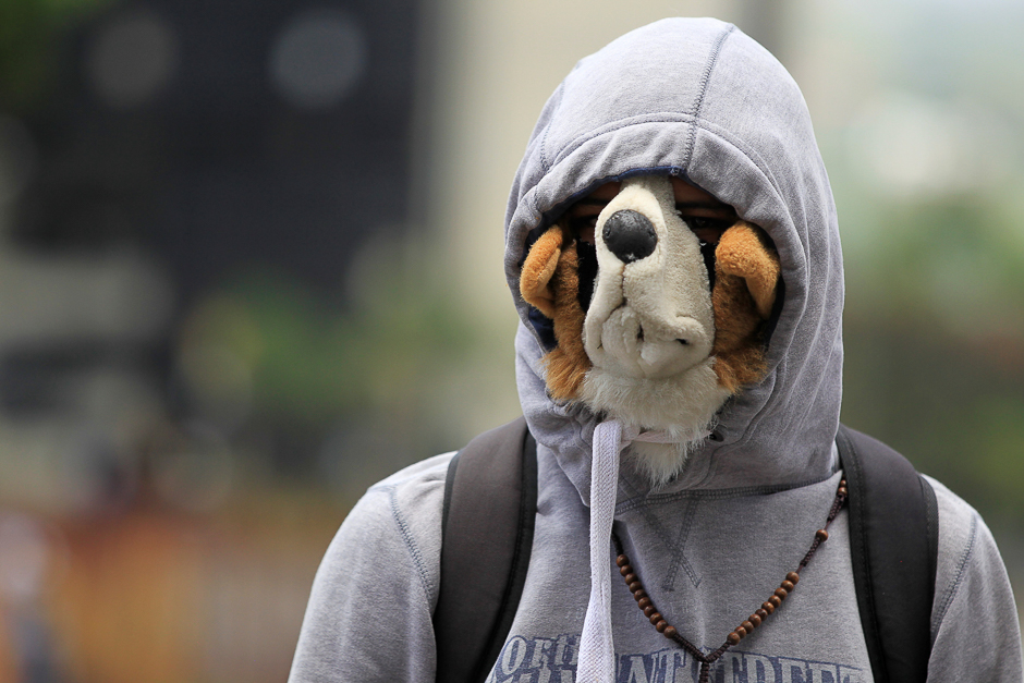 An oposition supporter wearing a dog mask rallies against Venezuela's President Nicolas Maduro in Caracas, Venezuela. PHOTO: REUTERS