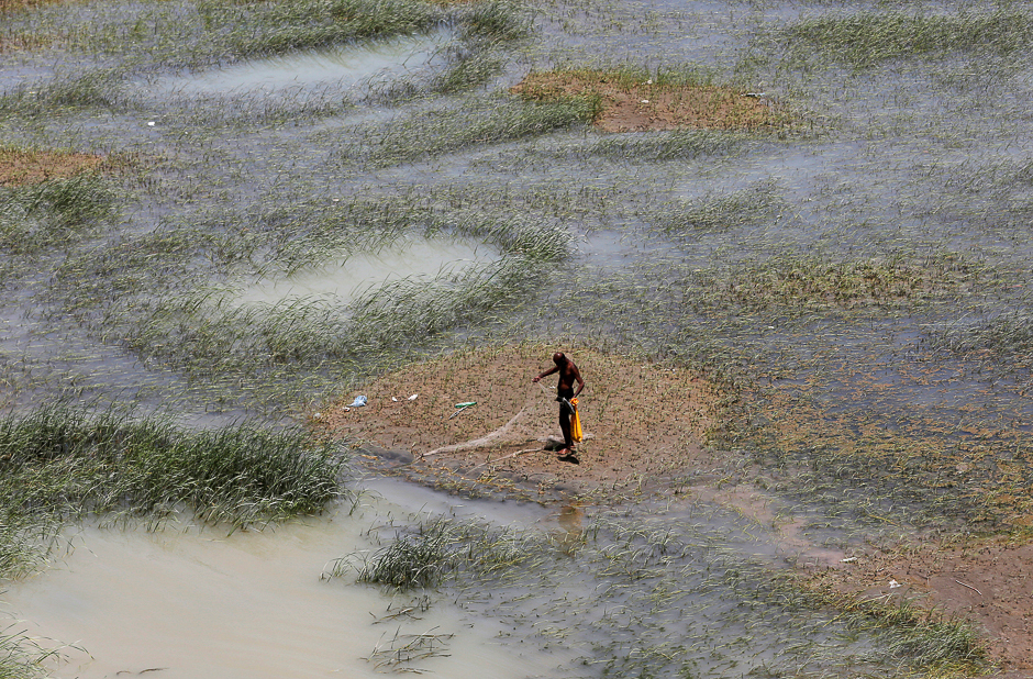 A fisherman stands as he checks his fishing net along the Indus River, Hyderabad, Pakistan. PHOTO: REUTERS
