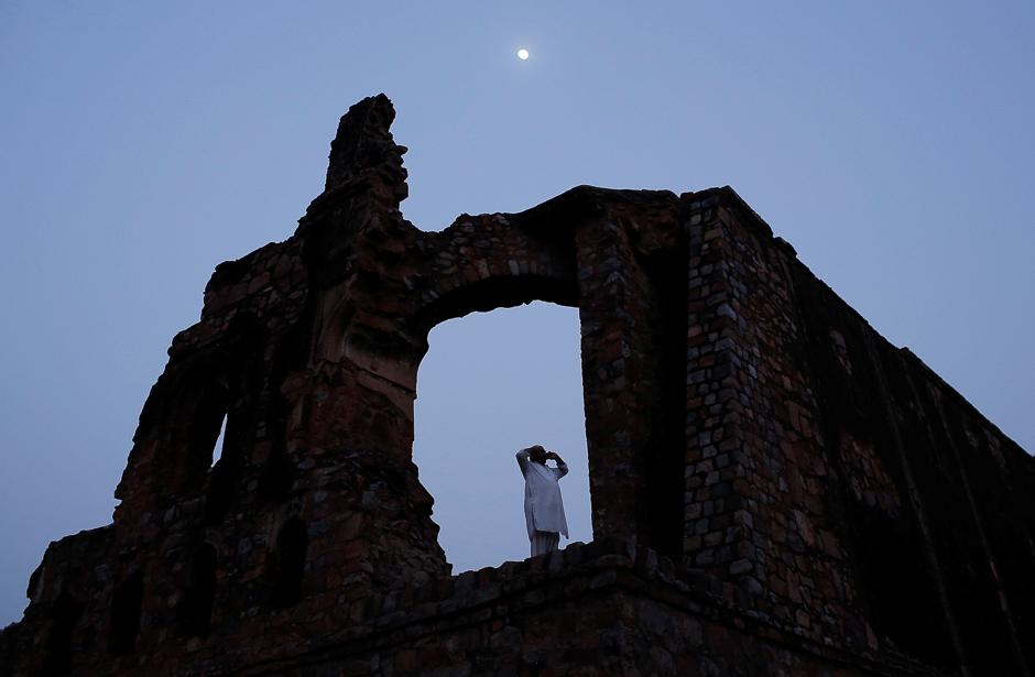 A Muslim man calls for the evening prayer after having his iftar (breaking of fast) meal during the holy month of Ramadan at the ruins of the Feroz Shah Kotla mosque in New Delhi, India. PHOTO: REUTERS