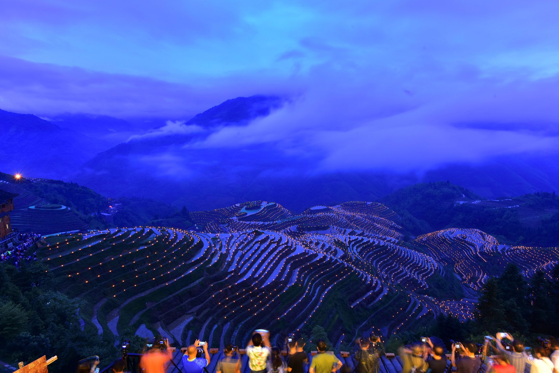 People take pictures of thousands of torches placed in terraced fields during a local festival praying for a good harvest, Guilin, China. PHOTO: REUTERS