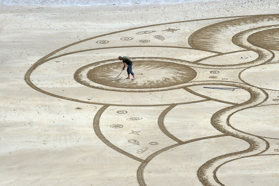 Sand artist Marc Treanor creates a work on the North Beach at Tenby Harbour, Pembrokeshire, Wales, Britain. PHOTO; REUTERS