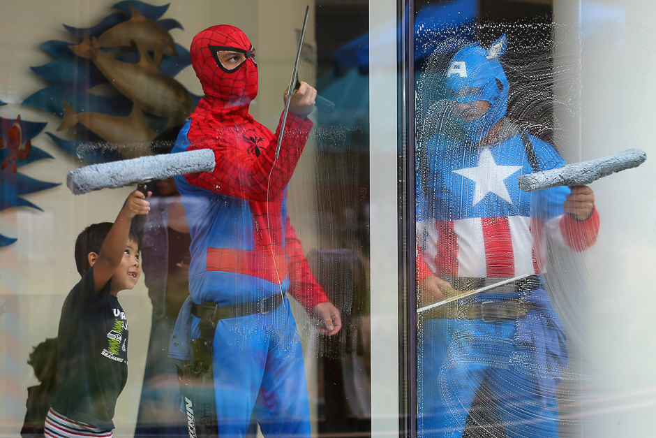 Four-year old Dominic helps window-washers dressed as superheroes as they work at Rady Children's Hospital in San Diego, California, US. PHOTO: REUTERS