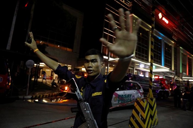 A security guard stops photographers from entering the vicinity of Resorts World Manila after gunshots and explosions were heard in Pasay City, Metro Manila, Philippines June 2, 2017. PHOTO: REUTERS