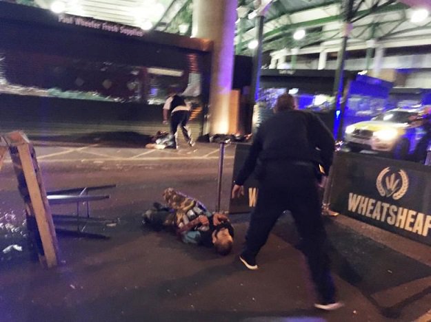 A man is seen on the ground after armed police officers opened fire on suspected attackers in Borough Market. PHOTO: REUTERS