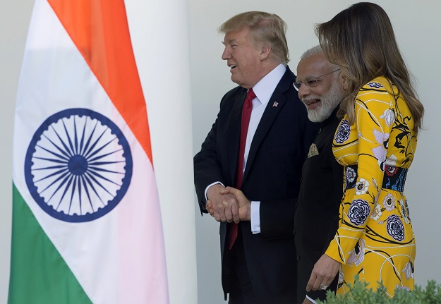 US President Donald Trump (L) shakes hands with Indian Prime Minister Narendra Modi (C) as he and First Lady Melania Trump (R) walk with him along the West Wing Colonnade past the Rose Garden as Modi arrives for meetings at The White House in Washington DC. PHOTO: AFP