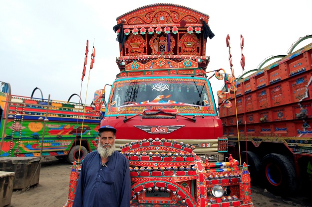 A security guard poses for a portrait in front of his favourite decorated truck at a truck stop outside Faisalabad, Pakistan. PHOTO: REUTERS
