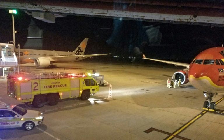 fire rescue personnel attend to the starboard engine of an airasia airbus a330 on july 4 2017 after the aircraft made an emergency landing at brisbane international airport photo afp