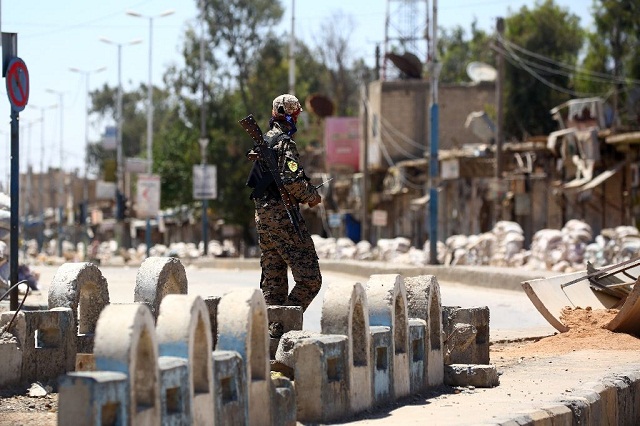 a member of the us backed syrian democratic forces sdf patrols a street in syrian town of tabqa in may 2017 as they advance their battle to the islamic state 039 s stronghold in nearby raqa photo afp