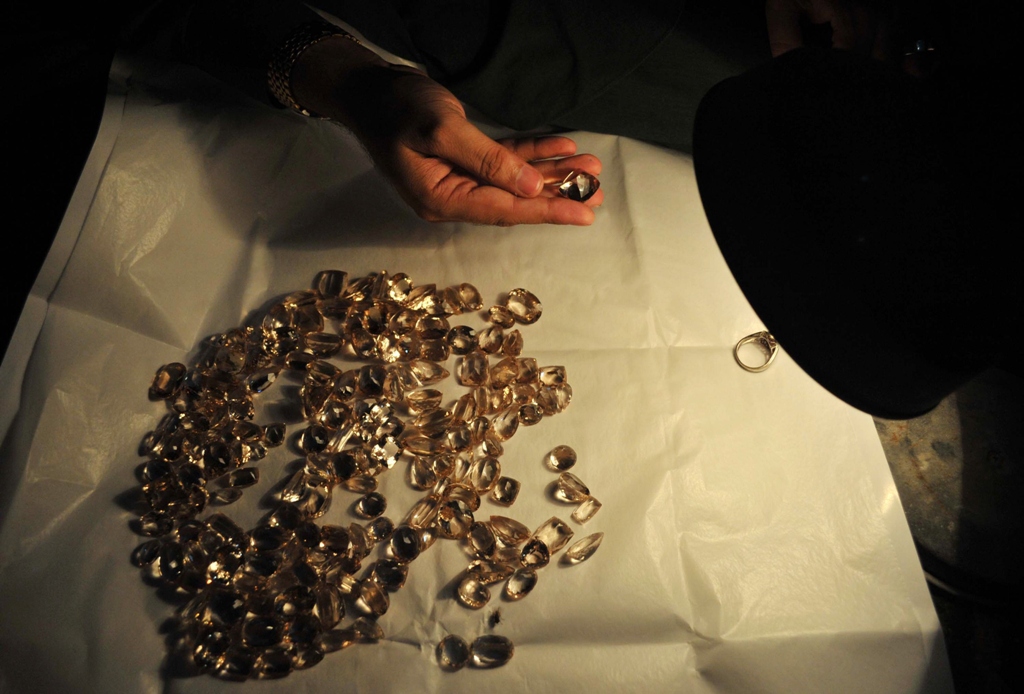 a craftsman checks a gemstone at a workshop in peshawar photo afp