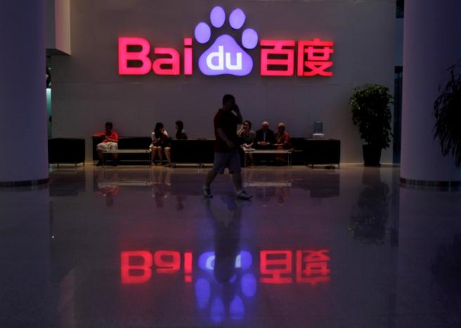 file photo   a employee uses his mobile phone as he walks past the company logo of baidu at its headquarters in beijing august 5 2010 photo reuters