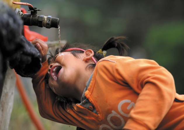 a girl drinks water from a tap photo reuters