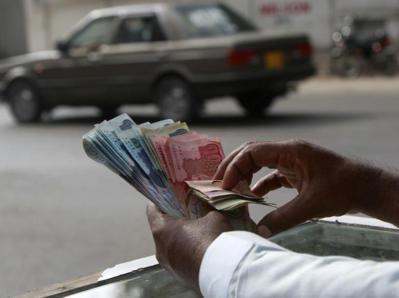 a money changer counts pakistani rupee notes in karachi photo reuters