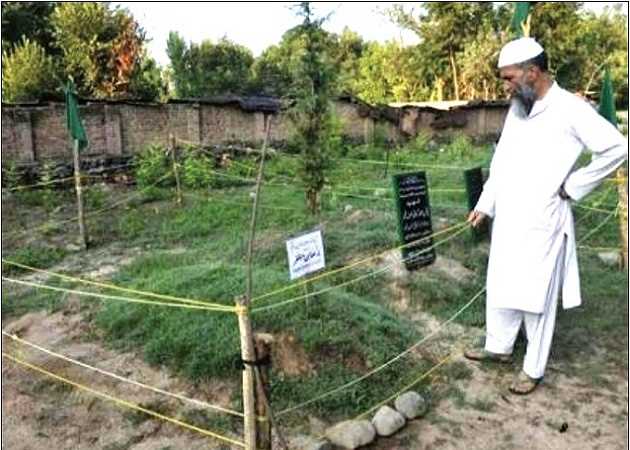 burhan father at the grave of his two sons