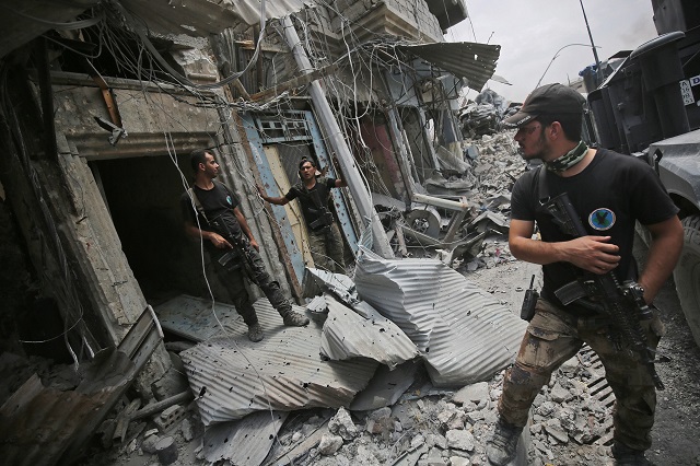 iraqi counter terrorism service cts members stand amid destroyed buildings in the old city of mosul on july 7 2017 during the iraqi government forces 039 offensive to retake the city from islamic state is group fighters the decaying bodies of foreign militants are piling up among the ruins of mosul where the last dozens of islamic state group fighters are mounting a desperate last stand photo afp