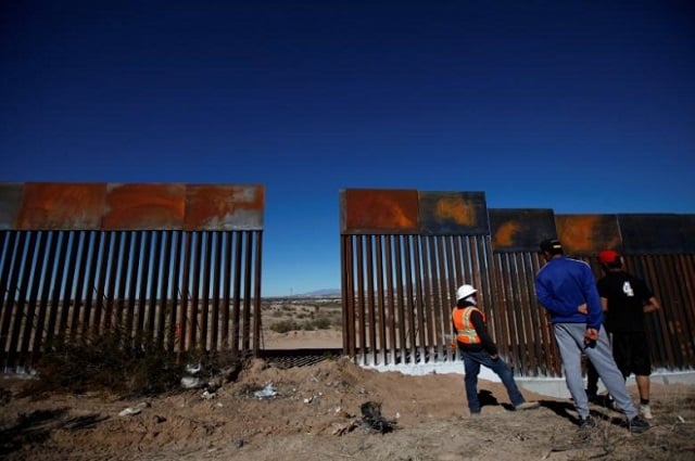 a worker chats with residents at a newly built section of the us mexico border fence at sunland park us opposite the mexican border city of ciudad juarez mexico january 26 2017 photo reuters