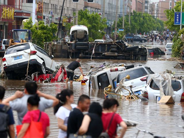 this photo taken on july 14 2017 shows people looking at submerged cars in a flooded street in yongji a county under the administration of the city of jilin in northeast china 039 s jilin province photo afp