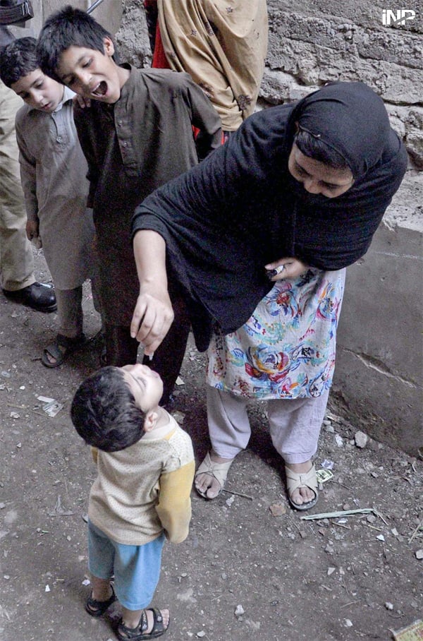 a polio worker administers polio vaccine to a child in the ongoing anti polio campaign photo inp