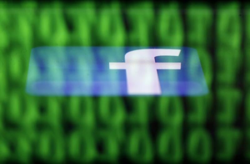 a facebook logo on an ipad is reflected among source code on the lcd screen of a computer in this photo illustration taken in sarajevo june 18 2014 photo reuters