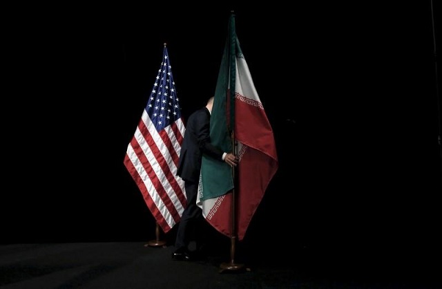 a staff member removes the iranian flag from the stage during the iran nuclear talks in vienna austria on july 14 2015 photo reuters