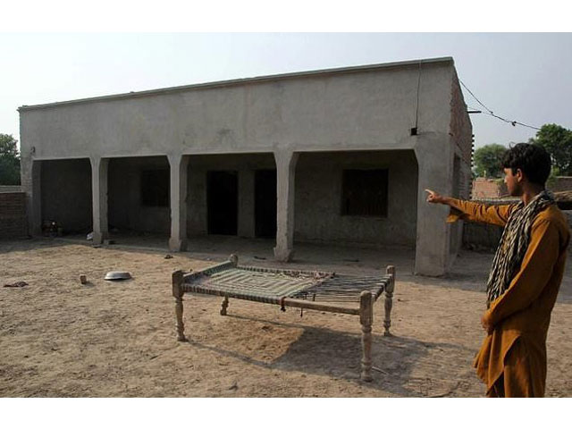a villager poses as he points to a house where a teenage girl was raped in the neighbourhood of raja ram in muzaffarabad a suburb of multan photo afp
