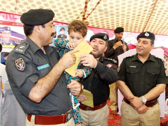 SSP Sajjad Khan distributes gifts among children of martyred police officers. PHOTO: EXPRESS 