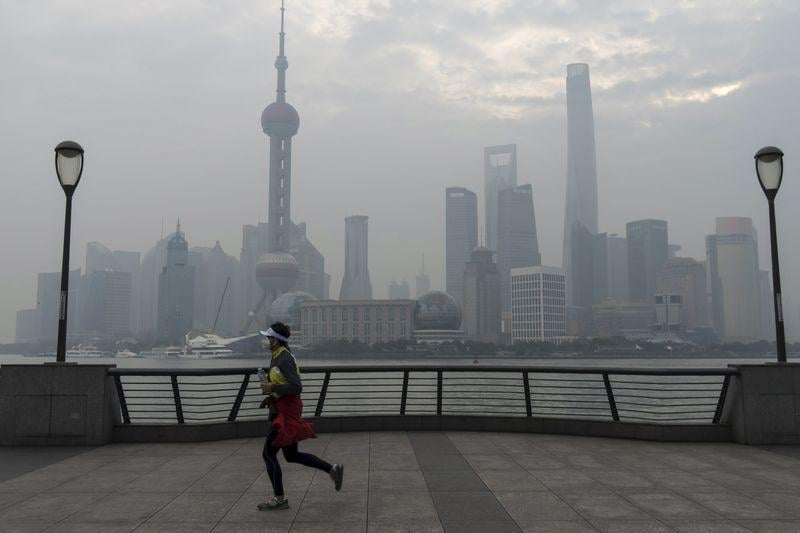 a jogger runs along the bund near the huangpu river across the pudong in shanghai china photo reuters