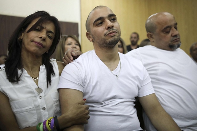 israeli soldier elor azaria c who shot dead a wounded palestinian assailant in march 2016 is embraced by his mother oshra l during a hearing at a military court in tel aviv on july 30 2017 judges were expected to rule on an appeal by an israeli soldier convicted of manslaughter and sentenced to 18 months in prison for shooting dead a prone palestinian assailant a case that has divided the country photo afp