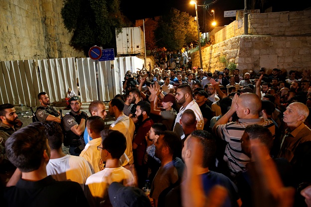 Palestinians shout slogans in front of Israeli border police after evening prayers outside the Lion's Gate of Jerusalem's Old City. PHOTO: REUTERS