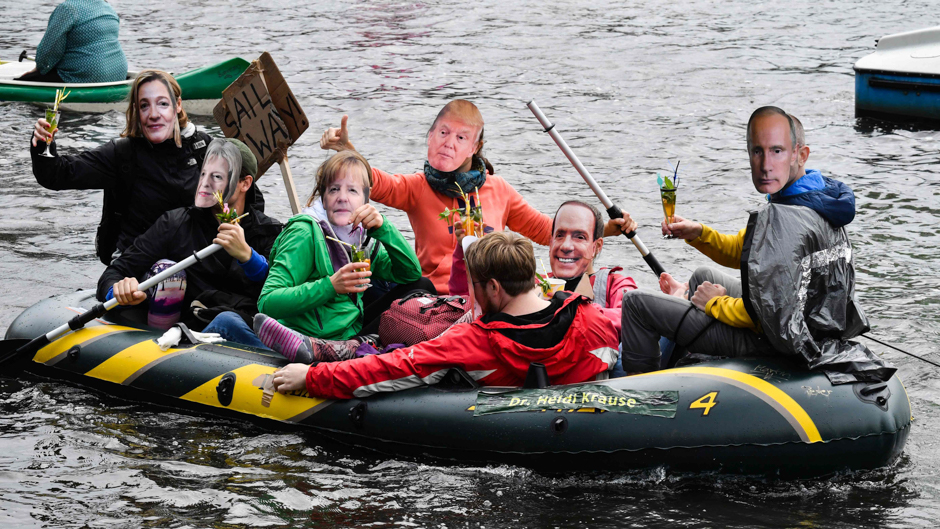 Protestors with masks of politicians drink cocktails in a boat on the Alster river during a demonstration called by several NGOs ahead of the G20 summit in Hamburg. PHOTO: AFP