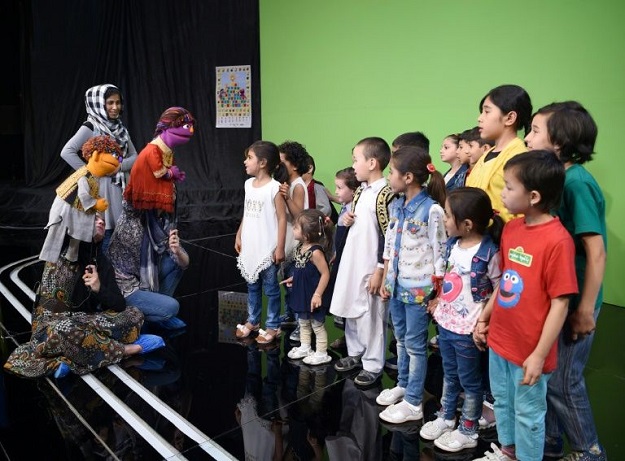 Afghan puppeteers Seema Sultani (L) and Mansoora Shirzad hold Sesame Street Muppets 'Zeerak' and 'Zari' as they meet children after a recording at a television studio in Kabul. PHOTO: AFP