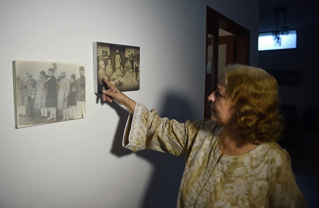 Jamshed Jahan Ara, 76, who migrated to Pakistan at the time of partition in 1947 at the age of six, points out a historical picture showing Mohammad Ali Jinnah,, Liaqat Ali Khan along with her paternal uncle after giving an interview to AFP at her residence in the Pakistani port city of Karachi. PHOTO: AFP