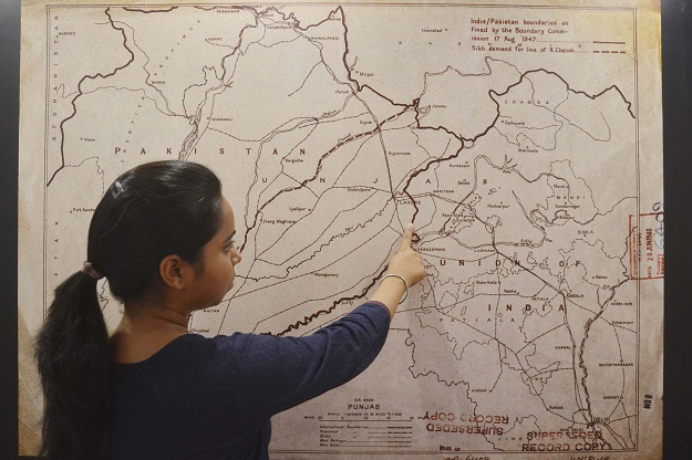 an Indian woman looking at a map of the India-Pakistan boundaries as fixed by the boundary commission on August 17, 1947 at the Partition Museum in Amritsar, India. PHOTO: AFP