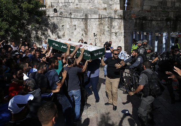 Palestinian mourners carry a coffin outside Al-Aqsa mosque compound as they refuse to undergo checking by Israeli security in order to access the religious site in Jerusalem's Old City. PHOTO: AFP