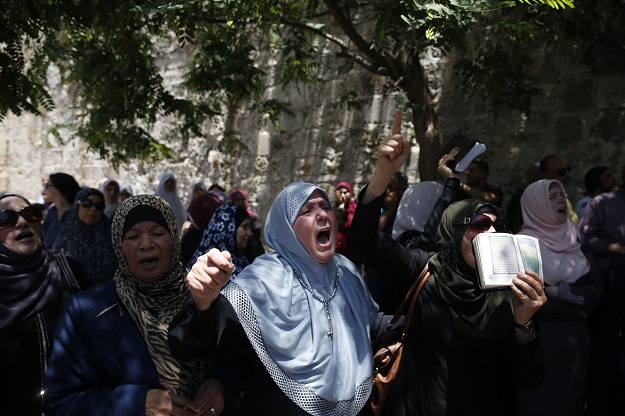 Palestinian women chant slogans outside the Lion's Gate, a main entrance to Al-Aqsa mosque compound, due to new security measures including metal detectors and cameras, in Jerusalem's Old City. PHOTO: AFP