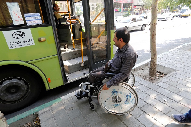 Behnam Soleimani, a 34-year-old Iranian computer teacher who uses a wheelchair, waits at a bus stop in Tehran, Iran. PHOTO: AFP