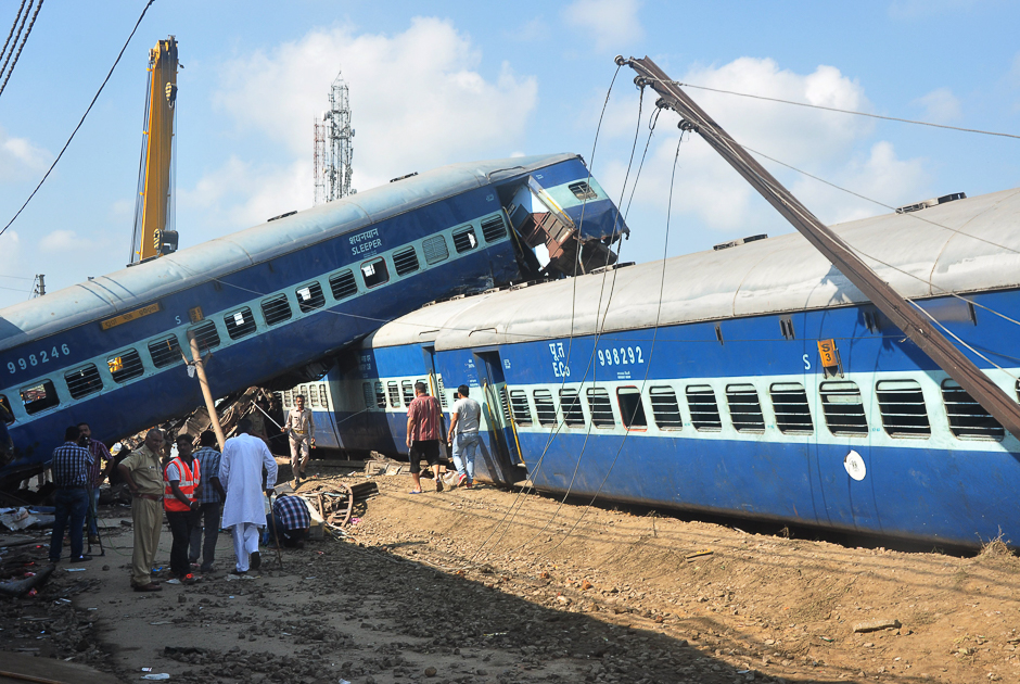 Indian policemen and emergency crew stand next to the wrecage of a train carriage after an express train derailed on the evening of August 19 near the town of Khatauli in the Indian state of Uttar Pradesh. PHOTO: AFP