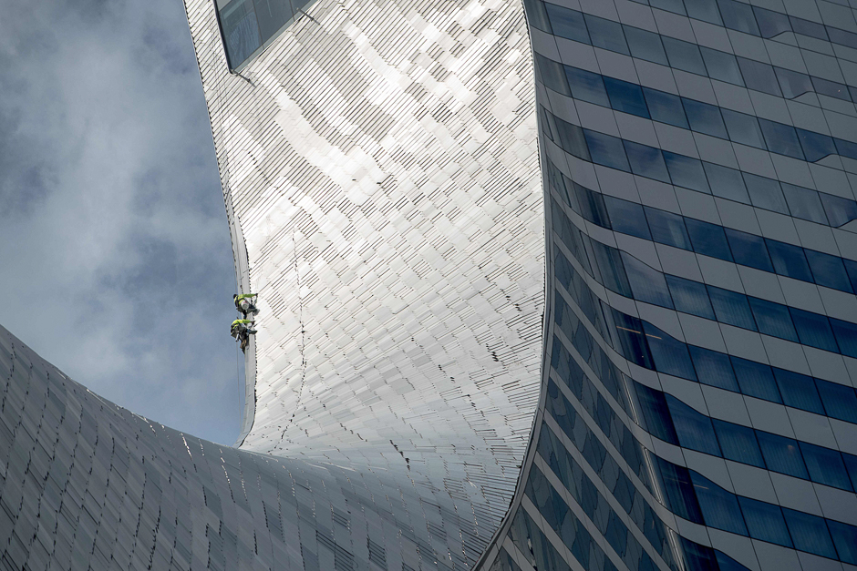 Workers inspect part of the roof of the Central Embassy building in Bangkok. PHOTO: AFP