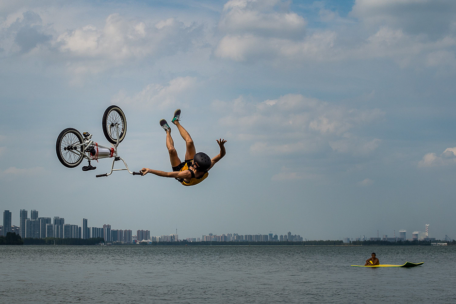 This photo shows a man falling off a bicycle while jumping into the Donghu Lake in Wuhan in China's central Hubei province. PHOTO: AFP