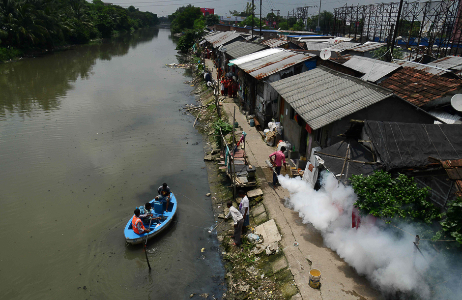 Indian health and municipal workers use a boat to help distribute pest-control chemicals to kill mosquitoes and larvae in Kolkata. PHOTO: AFP