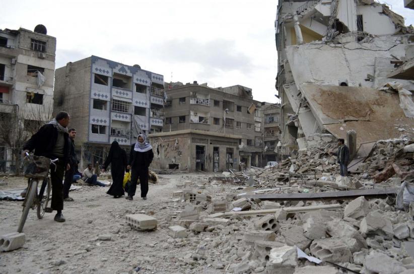 residents walk past damaged buildings after what activists said were air strikes by forces loyal to syria 039 s president bashar al assad in the douma neighborhood of damascus photo reuters