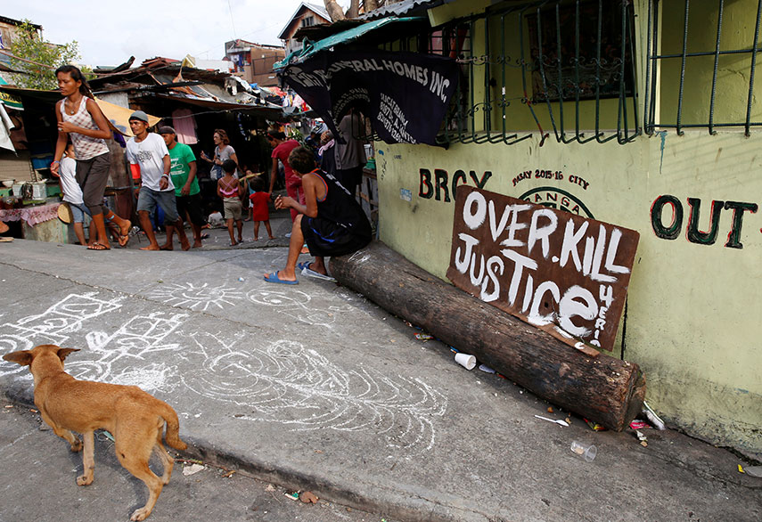 a crowd watches while police investigate the killing of man by unknown gunmen in the philippines capital of manila a cardboard sign left near his body read quot i am a drug pusher don 039 t be like me quot photo reuters