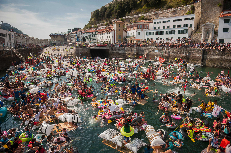 Thousands of revellers try to navigate their hand-made rafts in the port of the northen Spanish Basque city of San Sebastian during the 