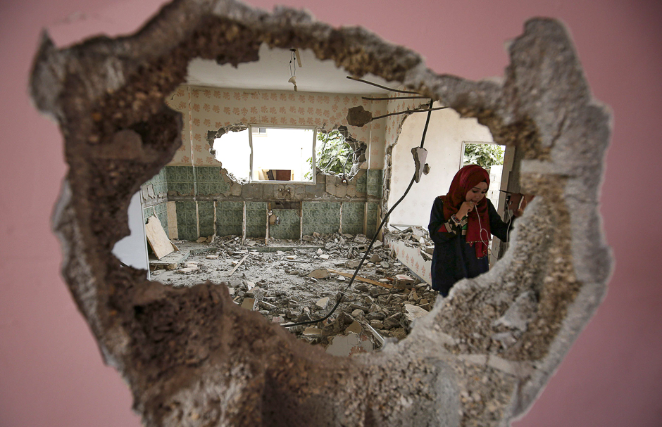 A woman checks the remains of the house of a Palestinian man, who killed three Jewish residents of a nearby Israeli settlement, after it was demolished by Israeli authorities in the West Bank village of Kobar, near Ramallah. PHOTO: AFP