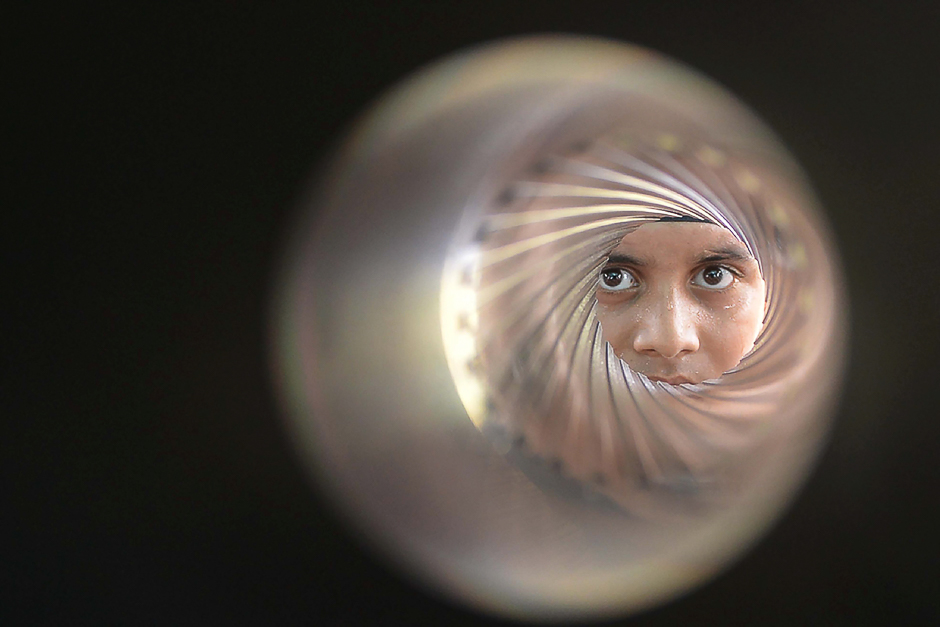 An Indian student poses as he looks down the barrel of an 84-MM rocket launcher during an Indian Army exhibition at Panther Stadium in Amritsar. PHOTO: AFP