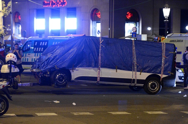 The van who ploughed into the crowd, killing at least 13 people and injuring around 100 others is towed away from the Rambla in Barcelona on August 18, 2017. A driver deliberately rammed a van into a crowd on Barcelona's most popular street on August 17, 2017 killing at least 13 people before fleeing to a nearby bar, police said.  Officers in Spain's second-largest city said the ramming on Las Ramblas was a 
