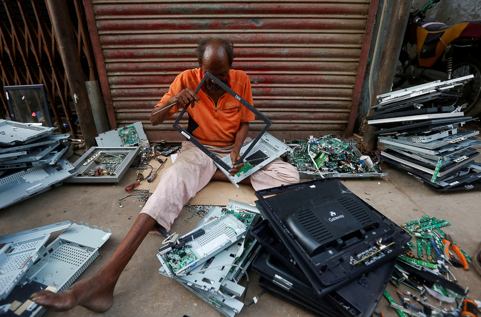 A man dismantles discarded computer monitors before delivering them to a recycling workshop in Karachi, Pakistan. PHOTO: REUTERS
