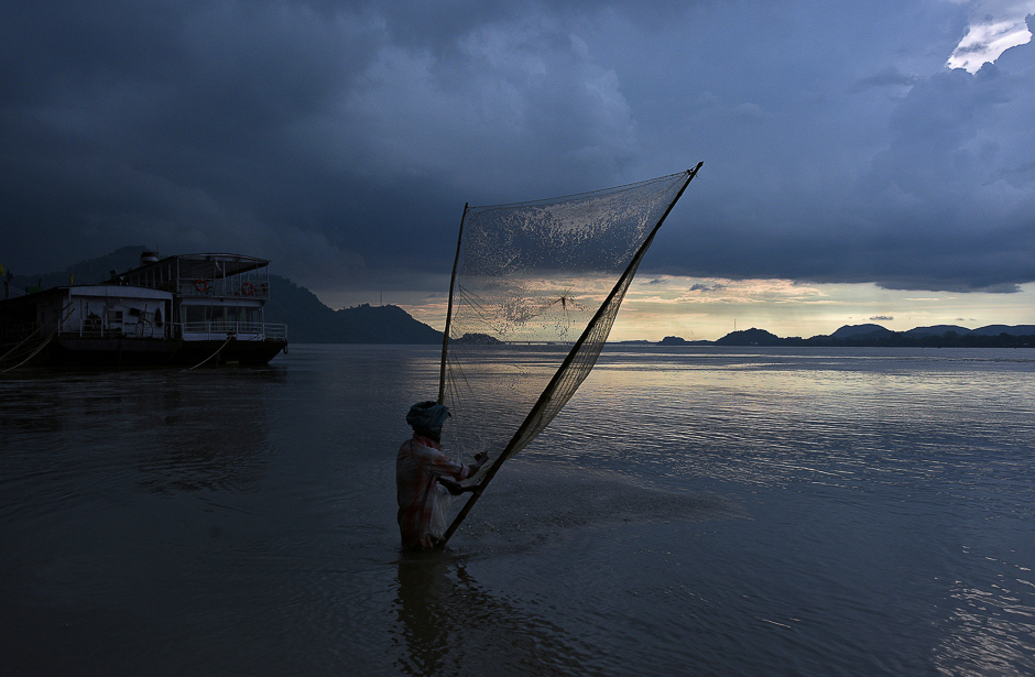 A man catches fish at the banks of the Brahmaputra river in Guwahati, India. PHOTO: REUTERS